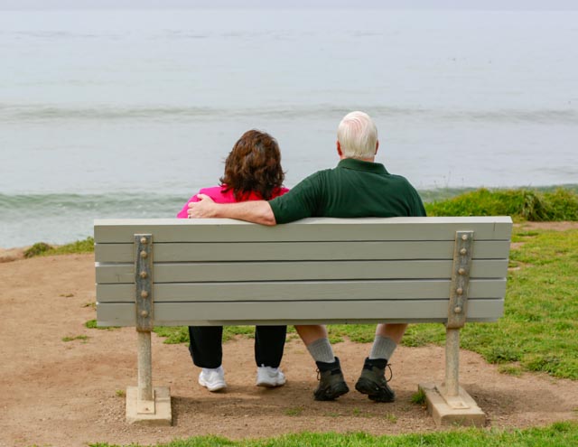 Rob & Ester sitting on a bench overlooking the ocean